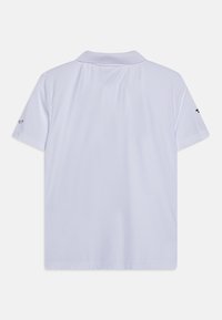 Hvit polo skjorte med et mykt, teksturert stoff. Har krage i klassisk stil og korte ermer, med en liten logo på den ene ermet.