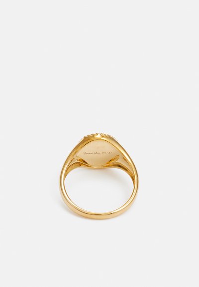 Gold ring with a smooth, polished surface. Features a rounded design and engraved detailing on the inner band. Shiny finish.