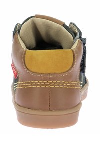 Stivali per bambini in pelle marrone e nocciola con un pannello in tessuto nero testurizzato, cuciture gialle e una chiusura in velcro sul lato.