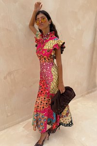 Kleurrijke, patchwork maxi-jurk met gerimpelde mouwen, bloem- en geometrische patronen, een ronde kraag en gecombineerd met een bruine clutch.