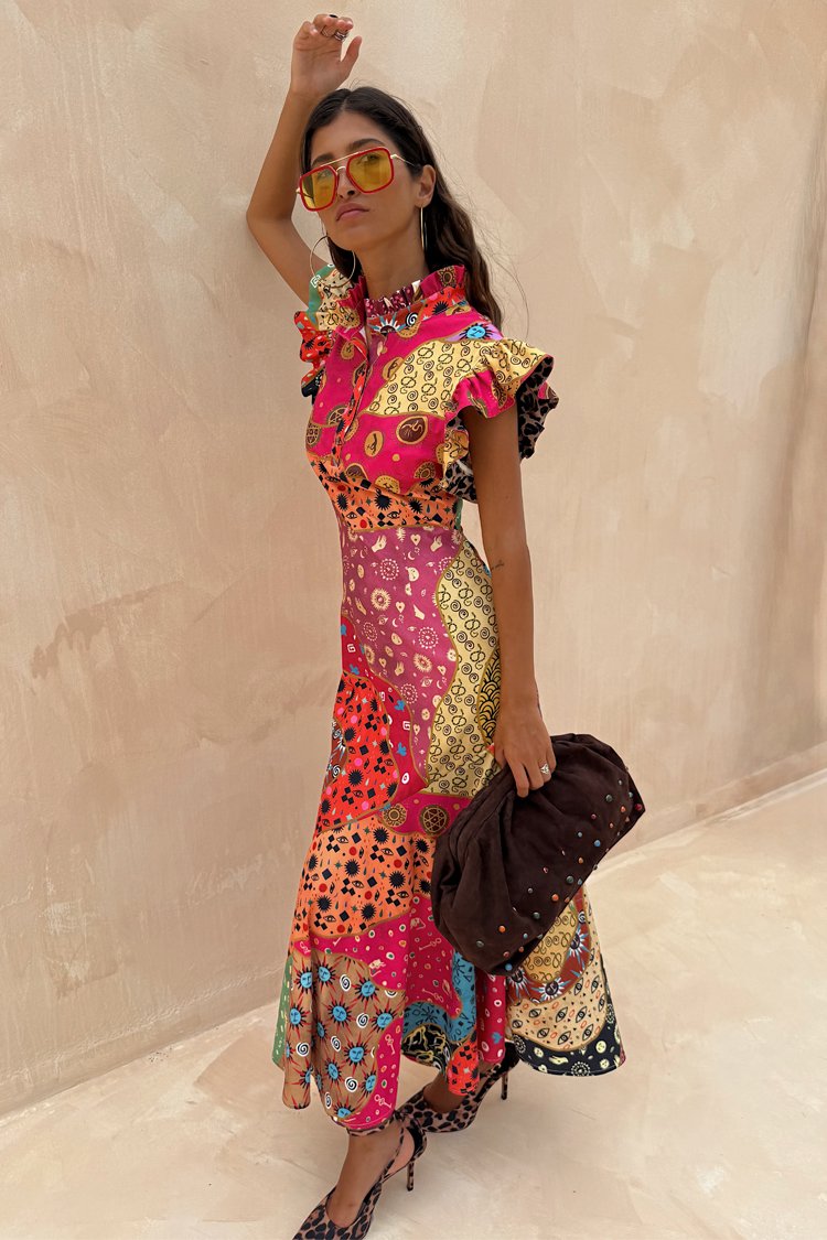 Kleurrijke, patchwork maxi-jurk met gerimpelde mouwen, bloem- en geometrische patronen, een ronde kraag en gecombineerd met een bruine clutch.