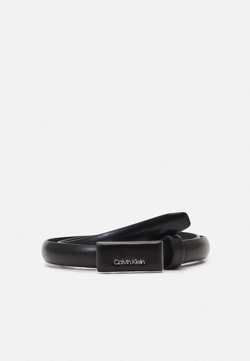 Ceinture en cuir noir enroulée avec une boucle métallique rectangulaire présentant le logo gravé Calvin Klein, affichée sur un fond clair uni.