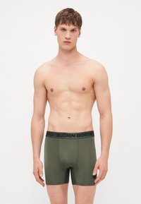 Ελιξίδας πράσινοι μποξέρ με μαύρη ζώνη που φέρει το λογότυπο "BJÖRN BORG". Κατασκευασμένα από λείο υλικό, εφαρμοστή σχεδίαση με απλή υφή.