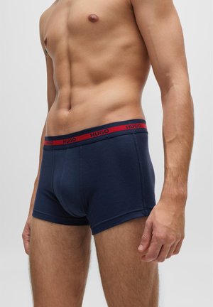 Navyblaue Baumwollboxershorts mit einem roten und blauen elastischen Bund, der das "HUGO"-Logo trägt, seitlichen Nähten und einer engen Passform.