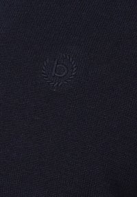 Dunkelblauer Strickstoff mit einem dezenten gestickten Emblem, das einen stilisierten Buchstaben "b" zeigt, der von einem Lorbeerkranz umrahmt ist.