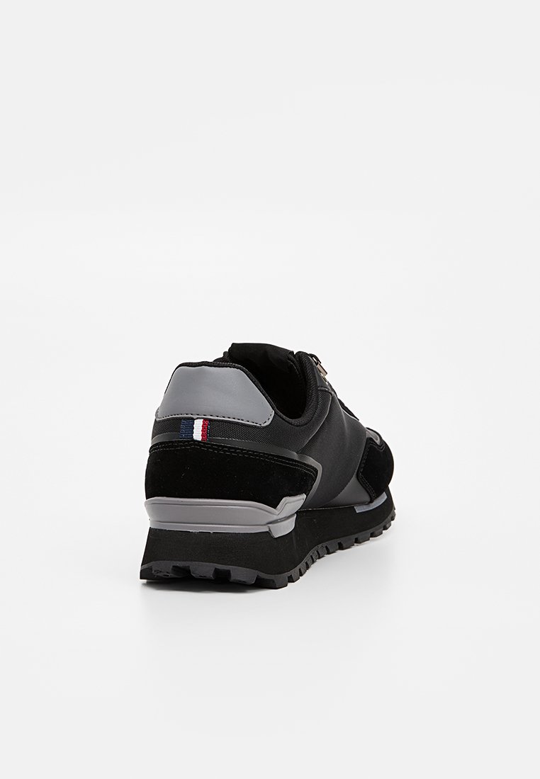 Czarne buty do biegania wykonane z zamszu i siateczki, z szarymi akcentami, cechujące się nieco podwyższoną podeszwą oraz małym detalem z flagą francuską na pięcie.