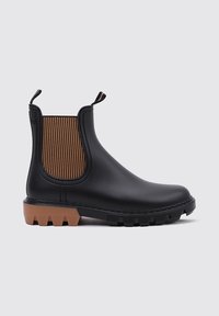Bottine Chelsea noire en caoutchouc avec un panneau élastique latéral marron texturé, un talon renforcé et une semelle extérieure en caoutchouc épaisse de couleur beige.