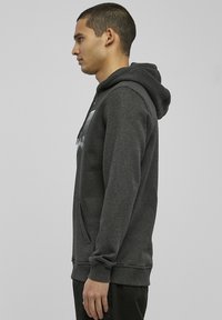 Gray hoodie made of soft fabric with a kangaroo pocket, drawstring hood, and ribbed cuffs. Features a graphic print on the front.
