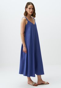 Abito maxi blu, senza maniche, con scollatura a V, realizzato in un tessuto morbido, caratterizzato da una silhouette ampia e fluente.