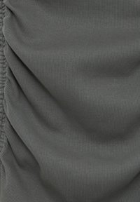 Tissu gris à texture côtelée, avec des détails froncés sur un côté. Doux et tombe en douceur.