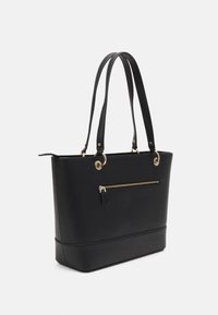 Mustat kankaiset kassit, joissa on teksturoitu pinta, kultaiset yksityiskohdat, kaksi pitkää kahvaa ja etupussukkasauma. Suora suorakulmainen pohja.