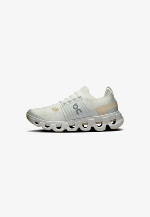 Scarpa sportiva bianca con una tomaia in mesh traspirante, dettagli testurizzati e una suola dalla forma unica con ritagli per una flessibilità migliorata.