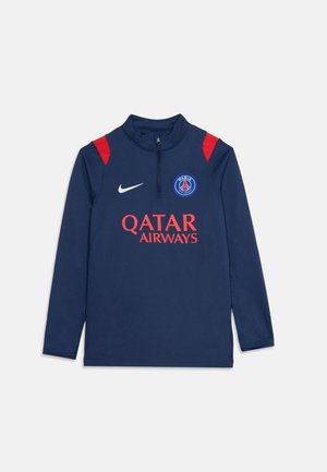 Tmavomodré dlhý rukáv tréningový top PSG s červenými akcentmi na ramenách, polovičný zips, logo Nike, erb Paris Saint-Germain a text sponzora Qatar Airways.