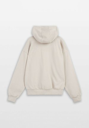 Jasno beżowy hoodie z kangurzą kieszenią, elastycznymi mankietami i regulowanym kapturem. Wykonany z miękkiego, teksturowanego materiału o luźnym kroju.