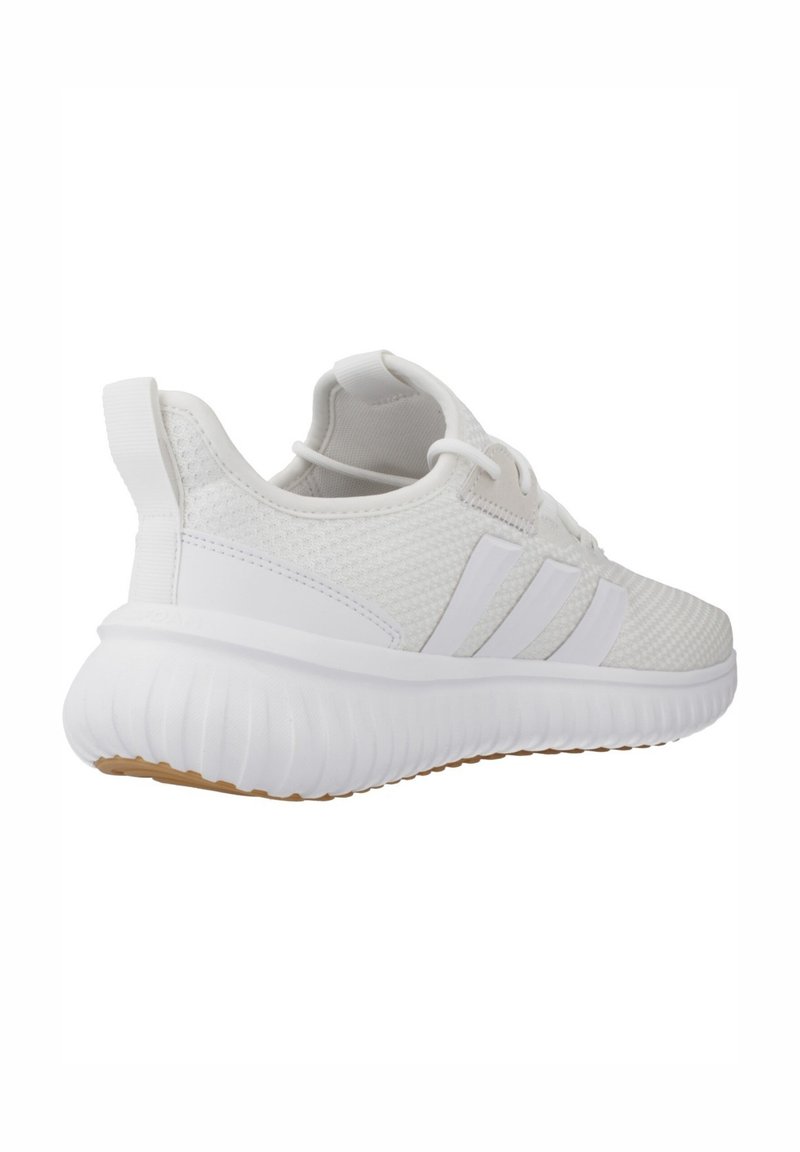 White athletic shoe with a mesh upper, textured design, three white stripes, and a cushioned white sole with a gum accent.