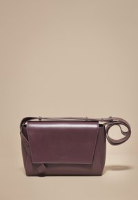 Vijolična usnjena ročna torba s strukturiranim dizajnom, z zloženim poklopcem in odstranljivim trakom, gladke teksture, z minimalnimi kovinskimi dodatki.