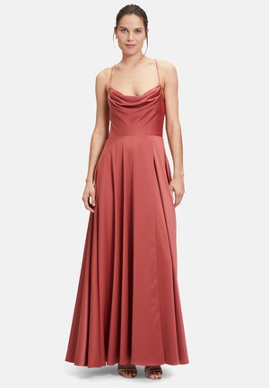 Maxikleid aus rostorangefarbenem Stoff, ausgestattet mit einem drapierten Cowl-Halsausschnitt, dünnen Trägern und einem ausgestellt geschnittenen Rock mit Falten. Insgesamt glatte Textur.