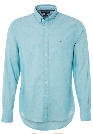 Lyseblå langærmet skjorte med knapper og knaplukning på kraven samt lille Tommy Hilfiger-logo på venstre bryst.
