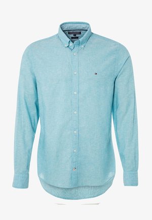 Chemise bleu clair à manches longues avec boutons, col boutonné et petit logo Tommy Hilfiger sur la poitrine gauche.