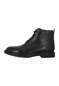 Botín de cuero negro hasta el tobillo con punta redonda, diseño de cordones, parte superior texturizada y una tira en la parte de atrás. Presenta una suela contrastante.