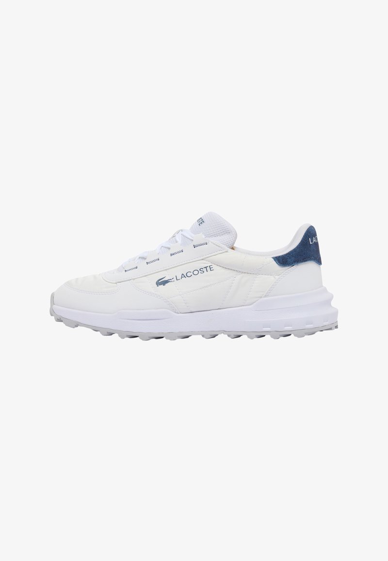 Baskets blanches Lacoste avec logo bleu et patch au talon, semelle texturée et languette en mesh, présentées de profil sur fond blanc.