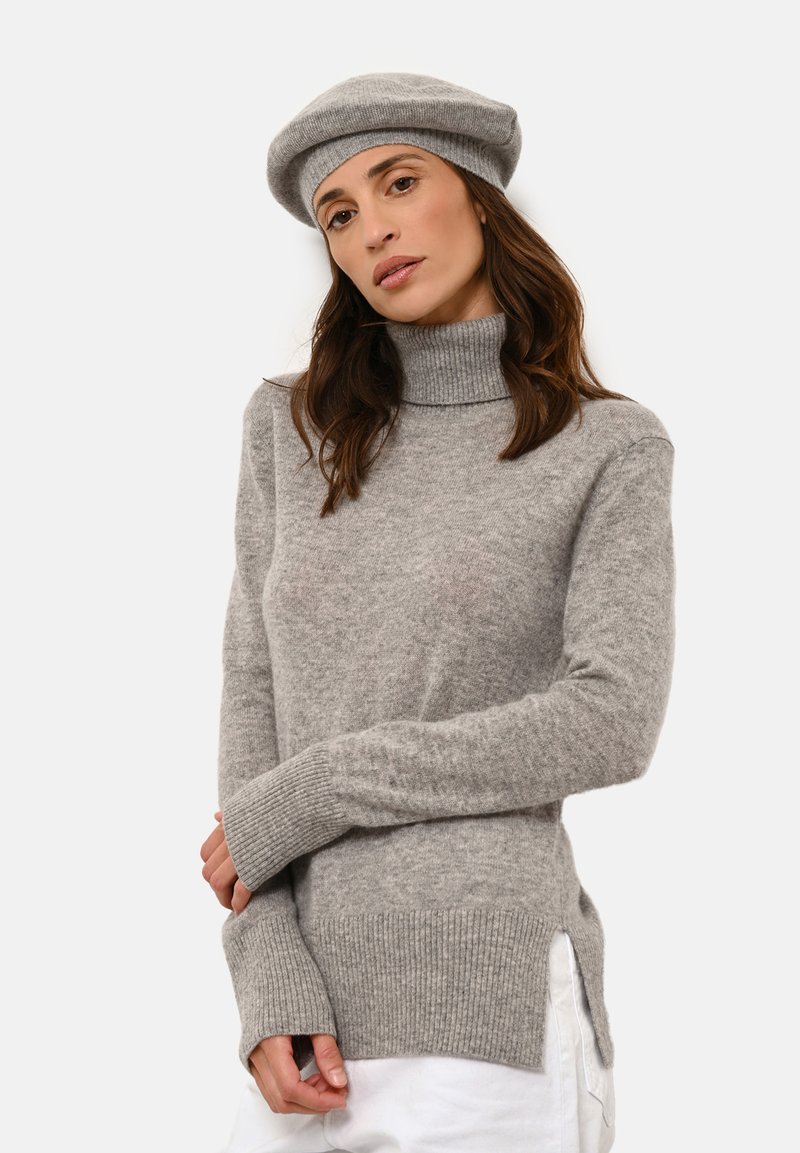 Šedý rolák se žebrovanými manžetami a spodním lemem, s postranními rozparky pro uvolněný střih. K tomu se hodí šedá čepice typu beret.