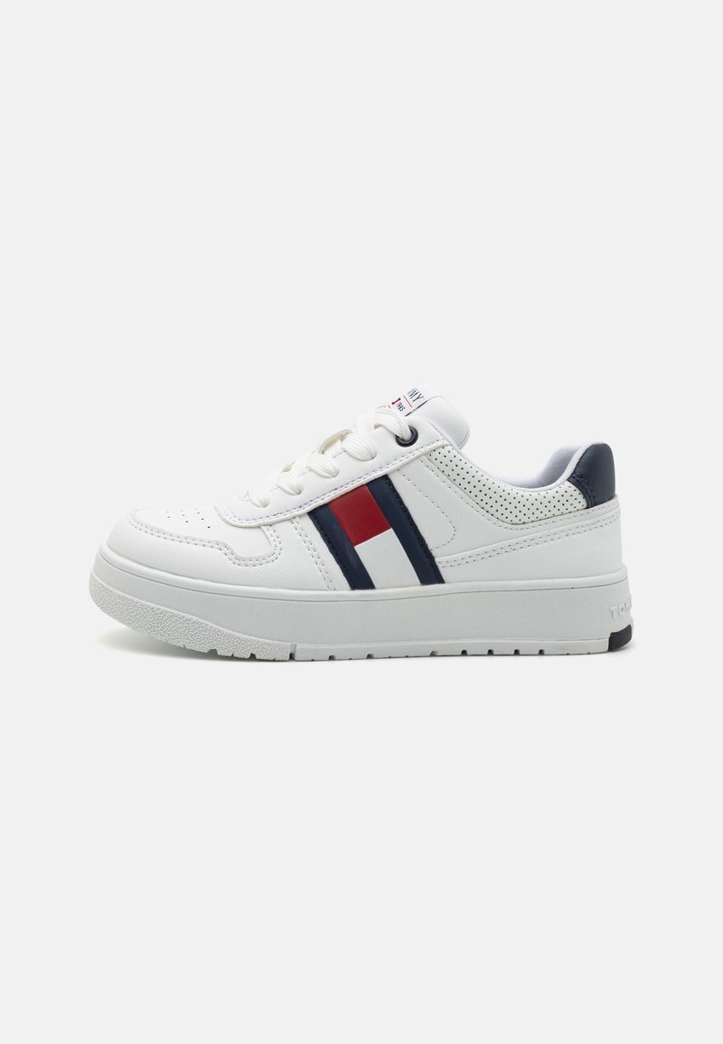 Sneaker bianco con texture perforata, strisce navy e rosse, suola in gomma e design con lacci. Tallone rinforzato per un supporto aggiuntivo.