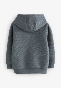 Hanorac gri texturat cu model în formă de diamant, prevăzut cu glugă și manșete și tiv striate. Finisajul neted al materialului adaugă adâncime.