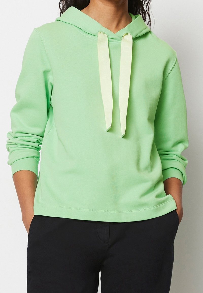 Vaaleanvihreä huppari kengurutaskulla, resorikahdilla ja vastavärisillä kermaisen sävyisillä nauhoilla. Pehmeä rakenne, rento istuvuus ja sileä kangas.