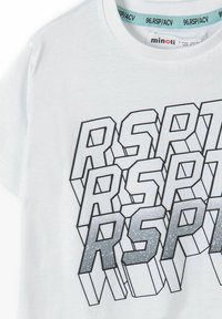 Balts kokvilnas T-krekls ar 3D ģeometrisku grafiku pelēkā krāsā, papildinātu ar spīdīgām akcentiem. Īsas piedurknes un apaļa kakla izgriezums.