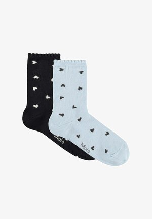 Par de calcetines tobilleros, uno negro con corazones blancos, otro azul claro con corazones negros, ambos con bordes ondulados y texto "Molo" en el pie.
