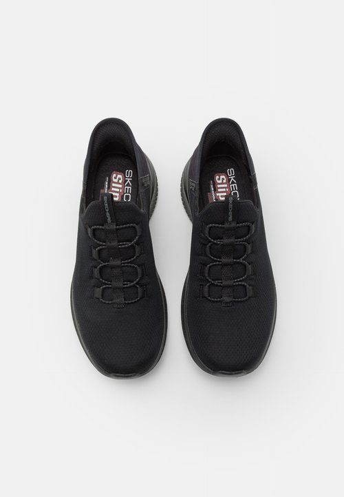 Mustia urheilukenkiä, joissa on teksturoitu verkkopinta, joustavat nauhat ja pehmustettu pohja. Suunnittelussa on matala profiili.