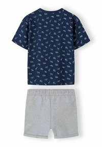 Camisa de manga corta azul marino con estampados de animales blancos, combinada con pantalones cortos de cintura elástica color gris claro con dobladillos enrollados.