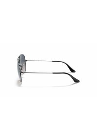 Occhiali da sole stile aviator con lenti scure e montatura in metallo argentato. Presentano punte delle aste in plastica nera e un design slanciato.