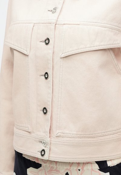 Φωτεινό ροζ τζιν μπουφάν με κοντό σχεδιασμό, δύο τετράγωνες τσέπες στο μπροστινό μέρος, μεταλλικά κουμπιά και ορατές λεπτομέρειες ραφής. Υφή υφάσματος.