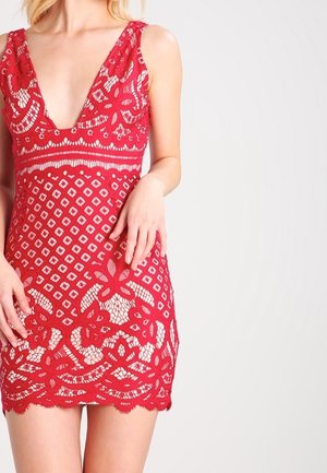 Robe en dentelle rouge avec un décolleté en V profond, des motifs floraux, une coupe ajustée et un ourlet festonné, avec un design semi-transparent et des détails complexes.