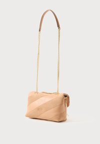 Borsa a tracolla in pelle beige con strisce diagonali in suede, dotata di una lunga tracolla in catena dorata e una finitura testurizzata. Dettaglio con chiusura magnetica.