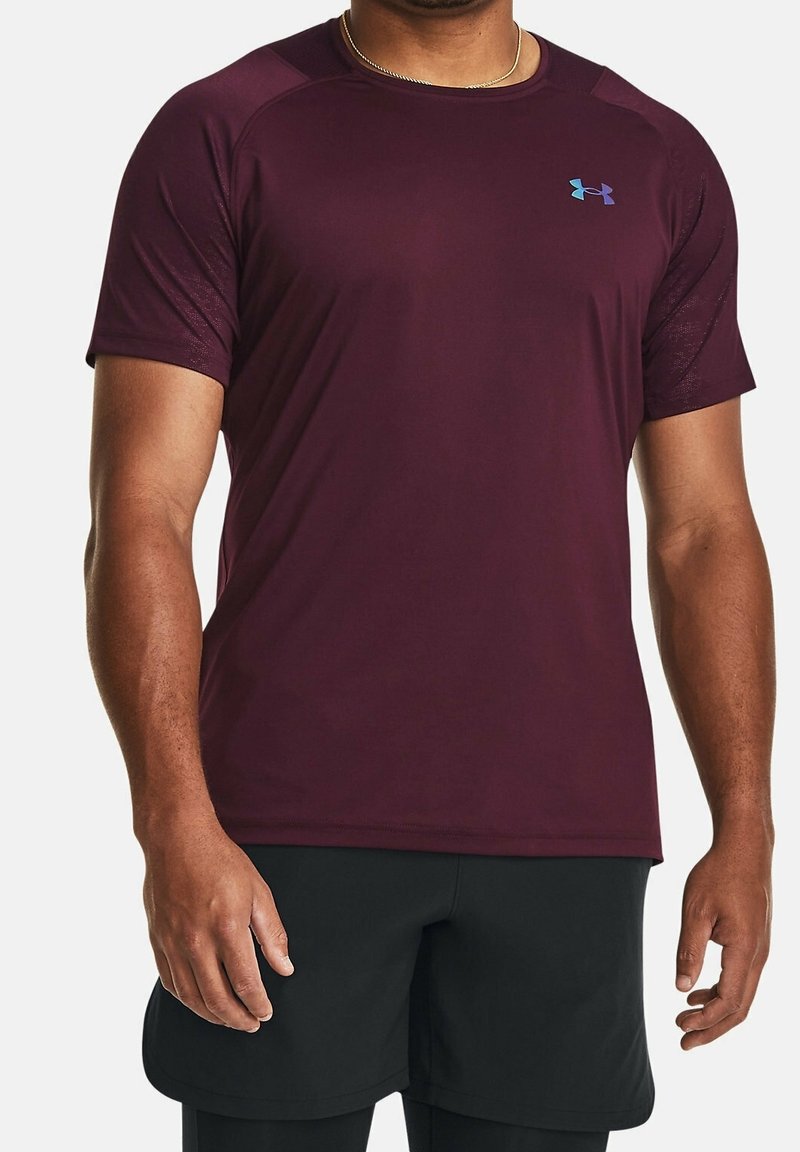 Camiseta deportiva marrón con mangas cortas, fabricada con un tejido suave que absorbe la humedad. Presenta un pequeño logo azul en el pecho.