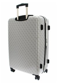 Valise rigide blanche avec un motif logo répété, équipée d'une poignée rétractable et de quatre roues noires pour une maniabilité aisée.