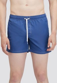 Pantaloni da bagno blu realizzati in tessuto leggero, con cordino bianco, vita elasticizzata e cuciture bianche lungo le cuciture.