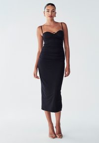Black midi dress with a fitted silhouette, thin spaghetti straps, ruching at the sides, and a keyhole detail at the bust. Smooth fabric.