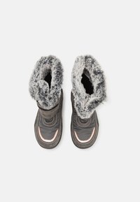 Bottes d'hiver en matériau noir avec un col en fausse fourrure grise. Présentent un bout arrondi, des coutures renforcées et un accent cuivre sur le côté.