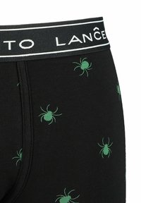 Czarne bokserki z zielonym wzorem pająków oraz czarnym paskiem z białym tekstem marki. Materiał bawełniany o gładkiej fakturze.