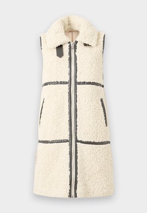 Ermeløs hvit sherpa-vest med stor krage, frontglidelås, to lommer og svarte detaljer.