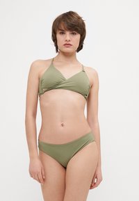 Olívazöld bikini szett, háromszögletű toppal, állítható pántokkal és minimalista szabású alsóval, sima, rugalmas anyagból készült.