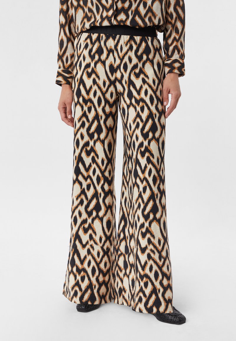 Weite Hose aus gemustertem Stoff in Beige-, Schwarz- und Brauntönen. Glatte Textur mit fließendem Design und elastischem Bund.