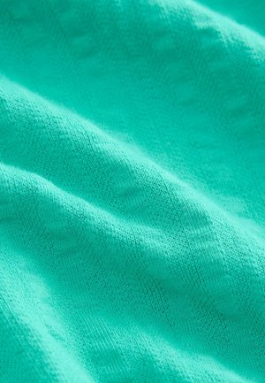 Tirkizna pletenina s teksturiranim uzorkom, koja pokazuje suptilne varijacije u nijansama i mekani, lagani izgled.