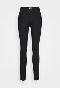 Černé žebrované legíny s vysokým pasem, na vrchu a po stranách mají malou nášivku Tommy Jeans a rozparky na kotnících.