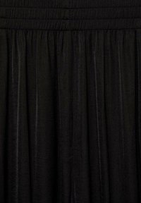 Czarna aksamitna spódnica z marszczonymi plisami i elastycznym paskiem w talii, tworząca miękkie pionowe fałdy.