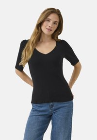 Black short-sleeve top with a V-neck, ribbed texture, and fitted silhouette, paired with blue jeans. Minimalist design and classic color.
